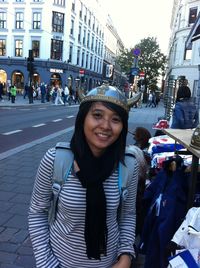 Portrait of smiling young woman on street in city
