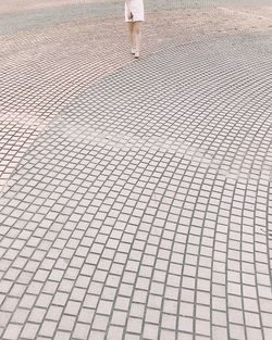 Low section of woman walking on tiled floor