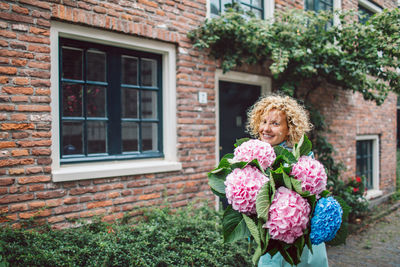 Portrait of smiling young woman holding bouquet