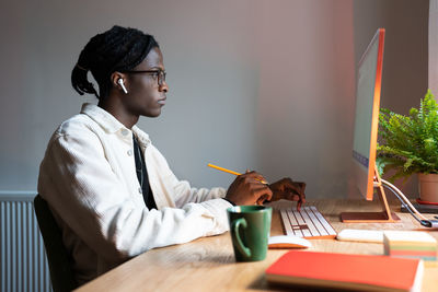 Progressive focused african american man designer working sits at office desk with computer