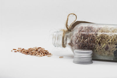 Close-up of bread in glass on table against white background