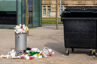 Messy garbage can on footpath