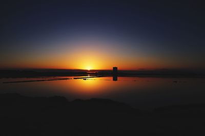 Silhouette of boat in sea at sunset