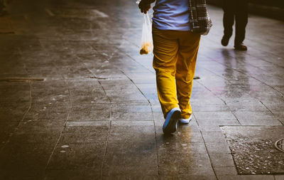 Rear view of woman walking on footpath