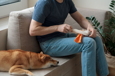 Adult man making diy homemade educational toys for dogs using a tutorial from the internet