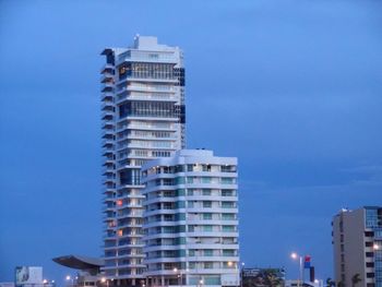 Low angle view of modern buildings against blue sky