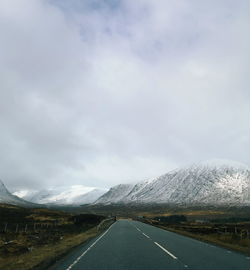 Road leading towards mountain range against sky