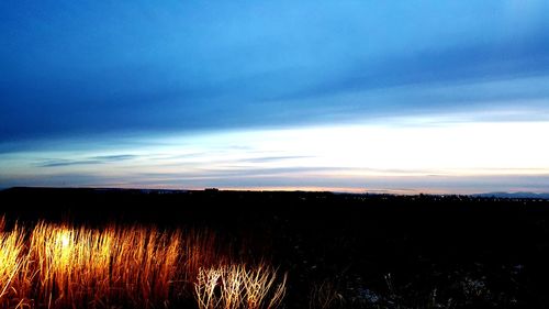 Scenic view of field against sky at sunset