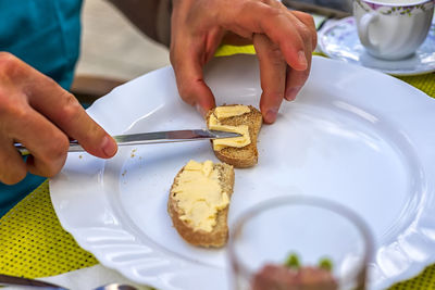 Close-up of man preparing food in plate