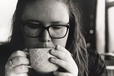 Close-up portrait of mid adult man holding coffee at home