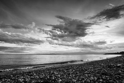 Scenic view of beach against cloudy sky