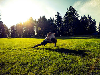 Full length of woman sitting on field against sky