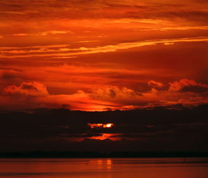 Scenic view of sea against dramatic sky during sunset