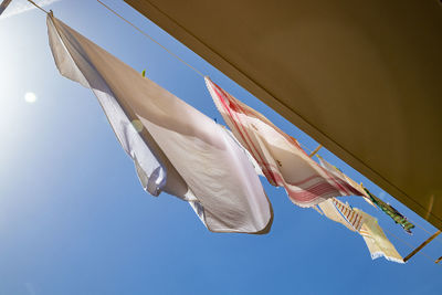 Low angle view of flags hanging against clear sky
