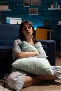 Portrait of woman sitting on bed at home