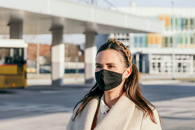 Young woman wearing black face mask in city. walking, confident, covid, corona, epidemic.