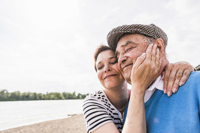 Portrait of couple holding water against sky