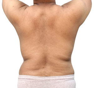 Rear view of shirtless man standing against white background