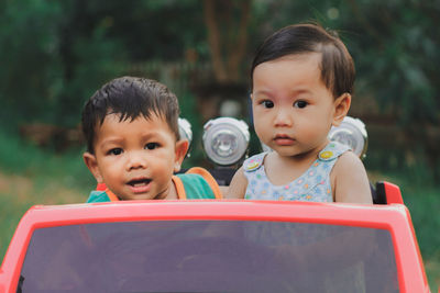 Siblings in toy car