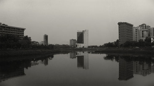 Reflection of buildings in lake against sky