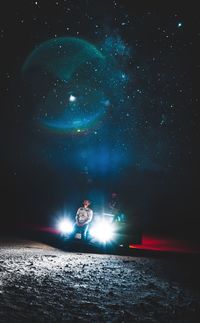 Man standing in illuminated star field against sky at night