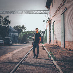 Full length portrait of man standing on railroad track