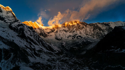 Scenic view of snowcapped mountains against sky during sunset