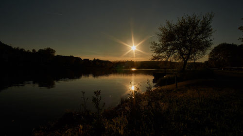 Scenic view of river against sky at sunset