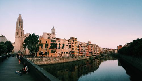 River amidst buildings in city against clear sky