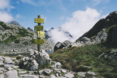 Information sign on rock against sky