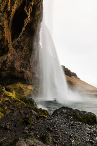 Scenic view of waterfall falling from mountain