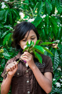 Young woman holding plant