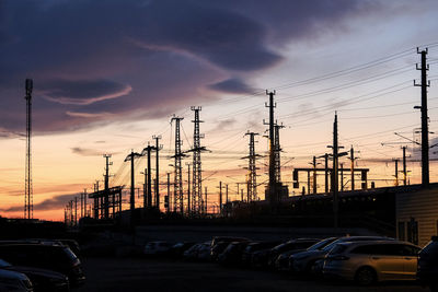 Cars in city against sky during sunset