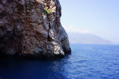 Rock formation in sea against sky