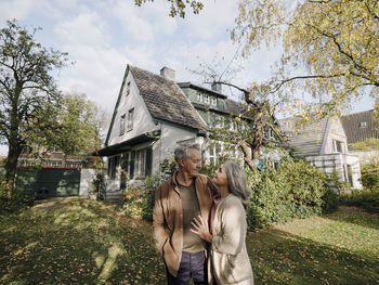 Senior couple in garden of their home in autumn