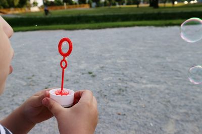 Close-up of girl blowing bubbles in park