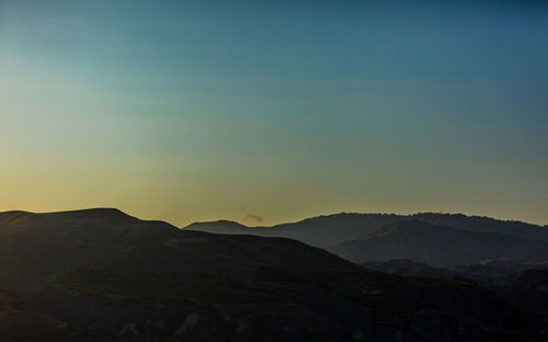 Scenic view of silhouette mountains against sky during sunset