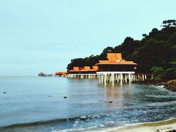 Building by sea against clear sky