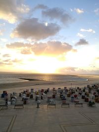People on beach against sky during sunset
