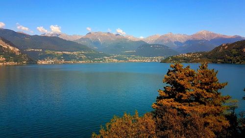 Scenic view of lake and mountains against blue sky