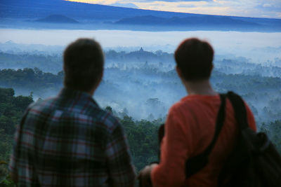 Rear view of people looking at mountain landscape