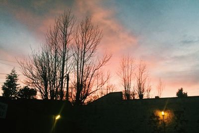 Silhouette bare trees against sky at sunset