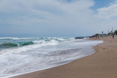 View of beach against cloudy sky