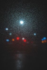 Close-up of illuminated lights against sky at night