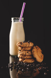 Close-up of cookies with milk on black background