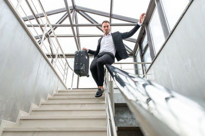 Businessman sliding on railing