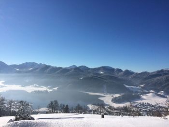 Scenic view of snowcapped mountains against clear blue sky