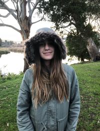 Portrait of smiling girl wearing warm clothing standing on field