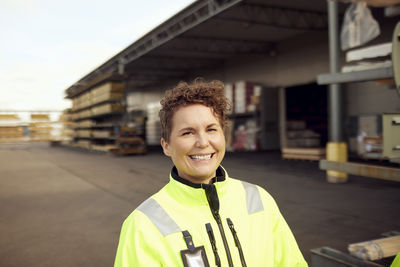 Portrait of cheerful mature female worker at industry