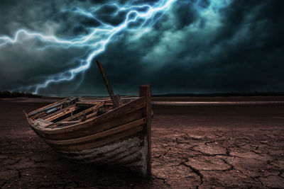 Abandoned boat on shore against sky